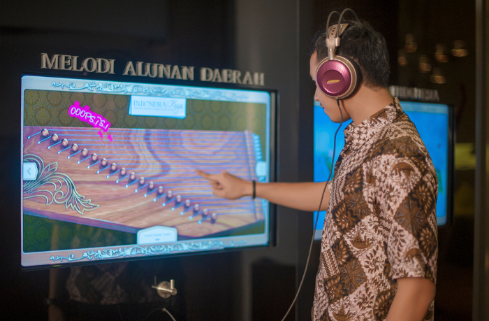 seorang anak menggunakan touch screen di Galeri Indonesia Kaya
